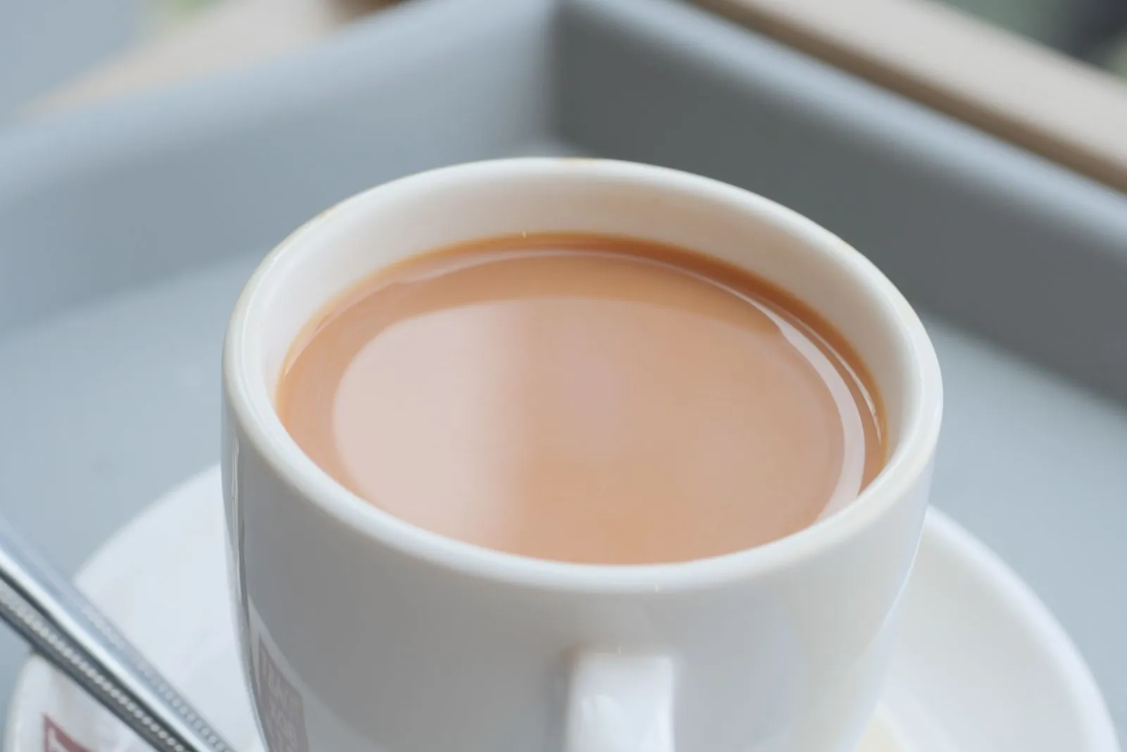 A steaming cup of tea in a white mug, providing a comforting and warm beverage experience.